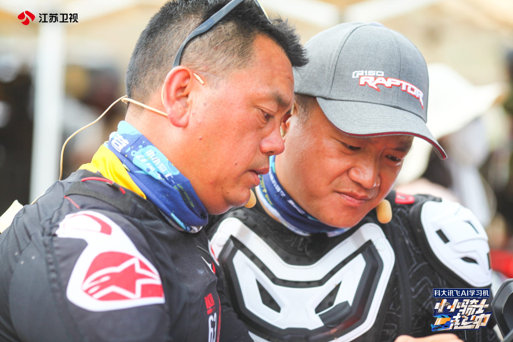 James TJ Lee and a production colleague in riding gear reviewing material during an outdoor shoot.