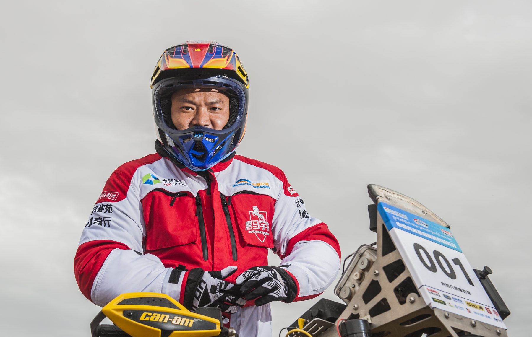 James TJ Lee in rally gear beside his ATV at the 2015 Qinghai Lake Off-Road Elite Invitational